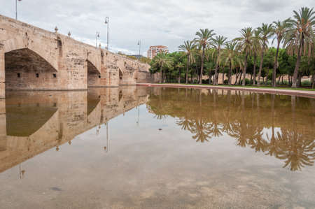 Medieval stone bridge over the Turia river promenade in the city of Valencia. Mediterranean...