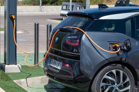 Fields. Balearic Islands / Spain; August 2020: dark-colored electric car charging its battery at a charging point in a supermarket car parkのeditorial素材