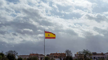 Spanish flag flying in the wind on a cloudy day. Mallorca island, Spainの写真素材