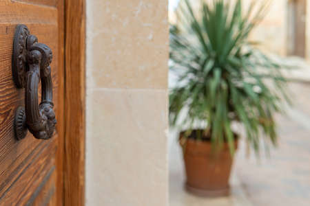 Close-up of an antique iron knob on an antique wooden door. Mallorca island, Spainの写真素材