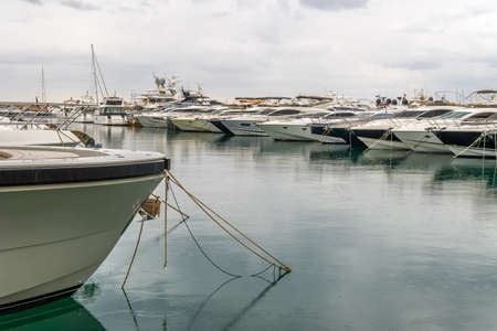 Luxury yachts moored in a marina of the island of Mallorca on a cloudy rainy dayの写真素材