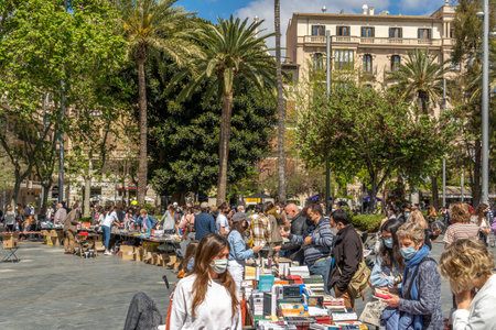 Palma de Mallorca; April 23 2021: Festivity of Sant Jordi or Book Day in the historic center of Palma de Mallorca in times of the Coronavirus pandemic. Facial mask and social distance. New normalのeditorial素材