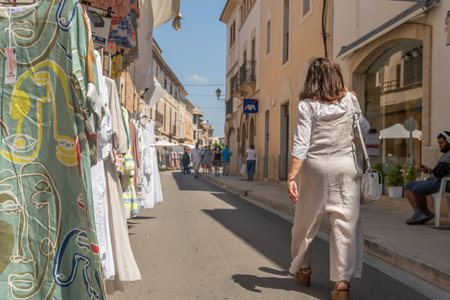 Campos, Spain; June 12 2021: Clothes stalls at the weekly street market in the Majorcan town of Campos. People walking with face mask. Coronavirus pandemic. New normality conceptのeditorial素材
