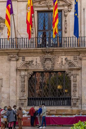Palma de Mallorca, Spain; April 23 2021: Festivity of Sant Jordi or Book Day in the town hall square of Palma de Mallorca in times of the Coronavirus pandemic. Facial mask and social distanceのeditorial素材