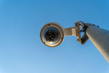 Security camera on a metal pole on a sunny summer afternoon. Security and control imageの写真素材