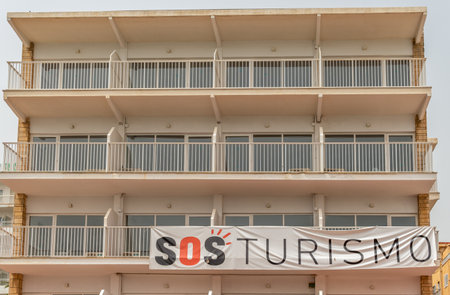 Palmanova, Spain; August 10 2021: Hotel establishment closed in the Mallorcan tourist resort of Palmanova due to the economic crisis resulting from the Covid-19 pandemic. SOS tourism poster in Spanishのeditorial素材