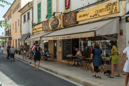 Campos, Spain; August 14 2021: Exterior facade of the famous Pomar pastry shop in the center of the Majorcan town of Campos with people having a drink on the terrace on a morning of the weekly marketのeditorial素材