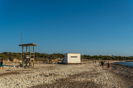 Es Trenc, Spain; October 11 2021: Old bunker of the Spanish civil war on the beach of Es Trenc, next to bathers, at sunset. Island of Mallorca, Spainのeditorial素材