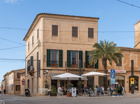 Santanyi, Spain; October 23 2021: General view of a cafeteria with customers, in a historic building, in the Mallorcan town of Santanyi, at sunsetのeditorial素材