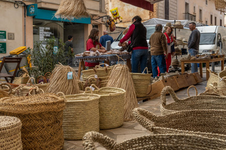 Santanyi, Spain; October 23 2021: Establishment selling traditional wicker baskets from the island of Mallorca, with custmoers in the background, out of focusのeditorial素材