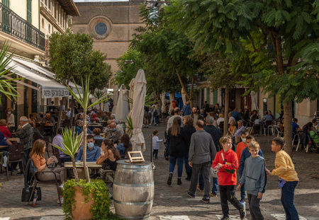 Porreres, Spain; October 31 2021: Annual autumn fair in the Majorcan town of Porreres, held on October 31. General view of tourists on the main street, with stalls and terraces of cafes with peopleのeditorial素材