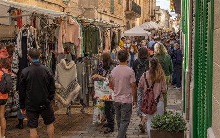 Porreres, Spain; October 31 2021: Annual autumn fair in the Majorcan town of Porreres, held on October 31. General view of tourists on the main street, with stalls and terraces of cafes with peopleのeditorial素材