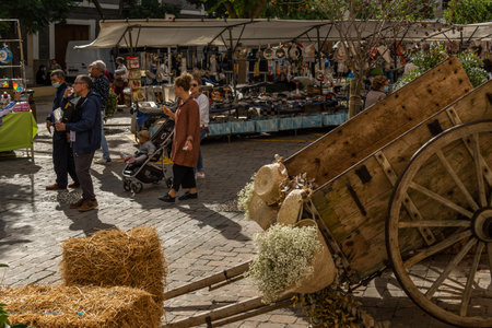 Porreres, Spain; October 31 2021: Annual autumn fair in the Majorcan town of Porreres, held on October 31. General view of tourists on the main street, with stalls and terraces of cafes with peopleのeditorial素材