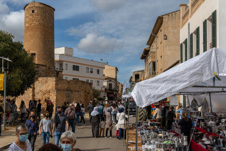 Porreres, Spain; October 31 2021: Annual autumn fair in the Majorcan town of Porreres, held on October 31. Kitchenware stand with many pans, pots and pans paella pan, with people walking around. New normalのeditorial素材