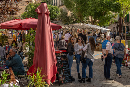Porreres, Spain; October 31 2021: Annual autumn fair in the Majorcan town of Porreres, held on October 31. General view of tourists on the main street, with stalls and terraces of cafes with peopleのeditorial素材