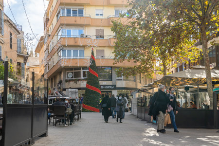 Manacor, Spain; November 26 2021: Historical center and cafeteria terraces with customers wearing face masks in the Majorcan town of Manacor, in Christmas times. New normal conceptのeditorial素材