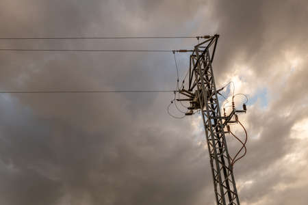 Electricity tower at sunset on a sunny day with clouds. Conceptual image of the world energy problemの写真素材