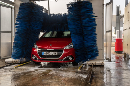 Campos, Spain; December 30 2021: Red Peugeot 208 model car being cleaned in a car wash tunnelのeditorial素材