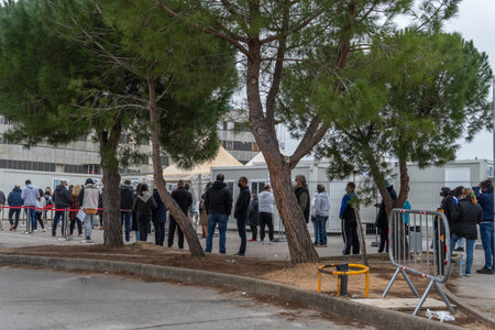 Palma de Mallorca, Spain; January 02 2022: Covid-19 vaccination point at the antique Son Dureta hospital in Palma de Mallorca. People with mask queuing for vaccination. New normality conceptのeditorial素材
