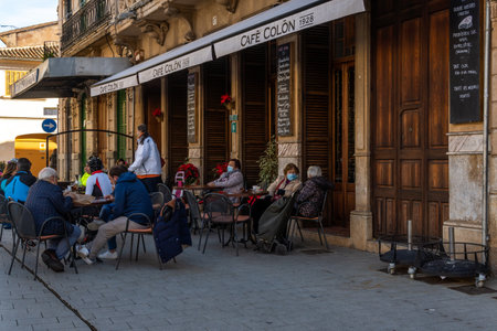Llucmajor, Spain; january 07 2022: Terrace of a cafeteria with customers wearing masks, in the town...