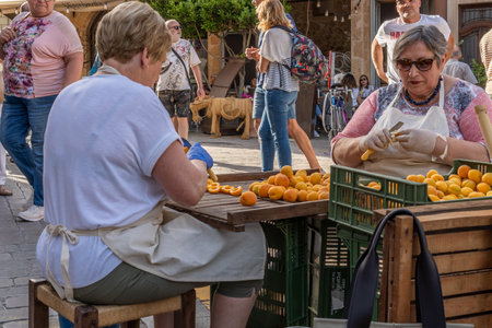 Porreres, Spain; June 04 2022: Annual apricot fair held in the Majorcan town of Porreres, Spain. Women workers cutting and preparing apricots for dessertsのeditorial素材