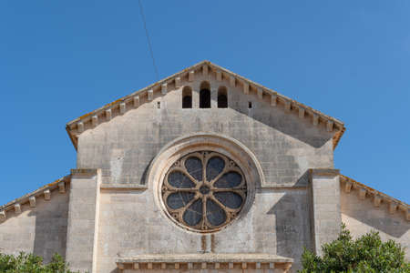 Main facade of the parish church of the Majorcan town of Calonge, at sunset on a sunny summer day....