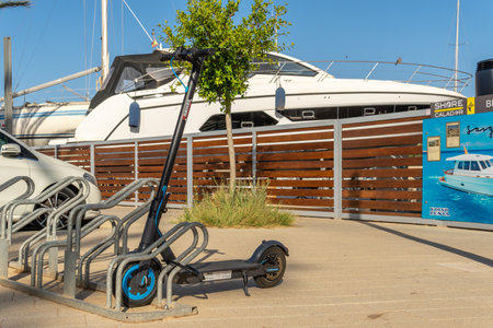 Cala dÂ´Or, Spain; june 25 2022: General view of the yacht club marina of Cala d'Or at sunset on a sunny summer day. Island of Majorca, Spain. parked electric scooterのeditorial素材
