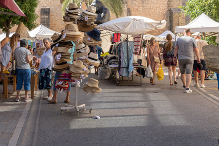 SantanyÃ­, Spain; july 09 2022: Weekly street market in the Majorcan town of Santanyi, Spain. Stalls selling clothes and fashion with tourists strolling aroundのeditorial素材