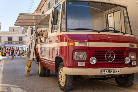 SantanyÃ­, Spain; July 09 2022: Street weekly market in the Mallorcan town of Santanyi. Vintage maroon Mercedes van, parked as a street food stand. Island of Majorca, Spain.のeditorial素材