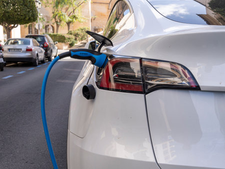 Felanitx, Spain; March 17 2023: White electric car of the Tesla company, parked on the street at an electric charging point. Felanitx, island of Majorca, Spainのeditorial素材