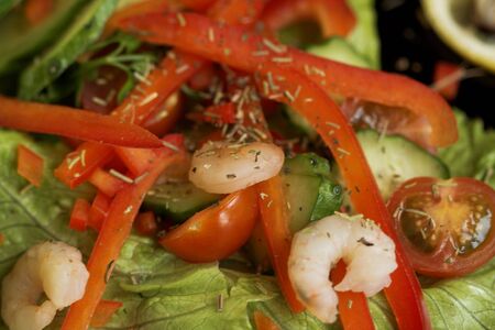 Freash vegetables salad with shrimps on the black dish.の写真素材