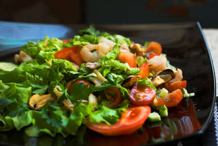 Freash vegetables salad with shrimps on the black dish.の写真素材