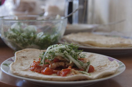 Tortilla stuffed with meat, onion and tomato sauce on a plateの写真素材