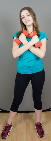 girl with dumpbells on grey background sport concept gymの写真素材