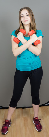 girl with dumpbells on grey background sport concept gymの写真素材