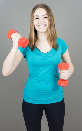 girl with dumpbells on grey background sport concept gymの写真素材