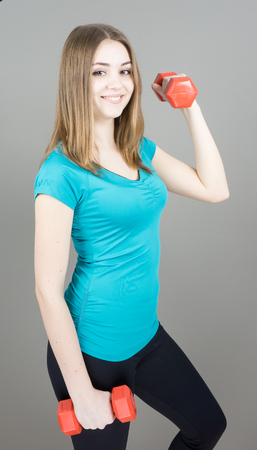 girl with dumpbells on grey background sport concept gymの写真素材