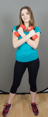 girl with dumpbells on grey background sport concept gymの写真素材
