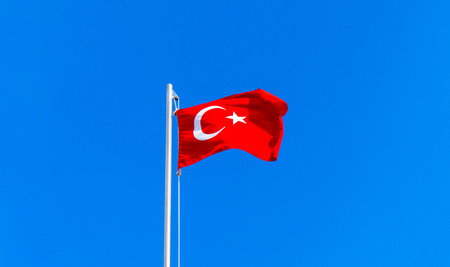 turkish flag waving in blue skyの写真素材