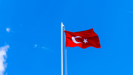 turkish flag waving in blue skyの写真素材