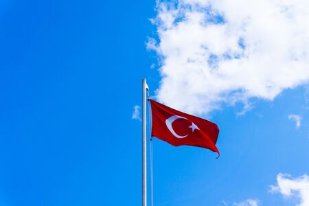 turkish flag waving in blue skyの写真素材