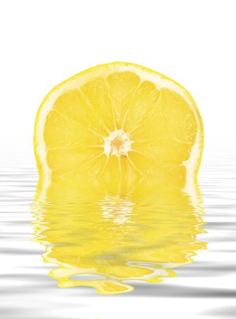 Slice of yellow grapefruit reflected in water.の写真素材