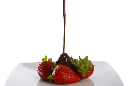Pouring chocolate on a delicious strawberries. Isolated on white background.の写真素材
