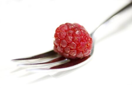 Raspberry on fork isolated on white background.の写真素材