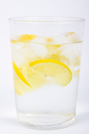 Detail of glass of water with lemons and ice.の写真素材