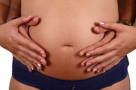 Male and female hands embracing the belly. Over white.