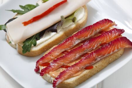 Delicious sandwich with gravlax, turkey and green vegetables.