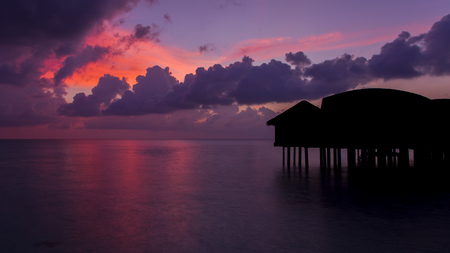 Gorgeous dusk in Maldives. Bungalows are black silhouette.の写真素材