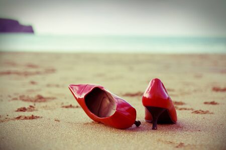 Red shoes in the beach. Cross processing filter added.の写真素材