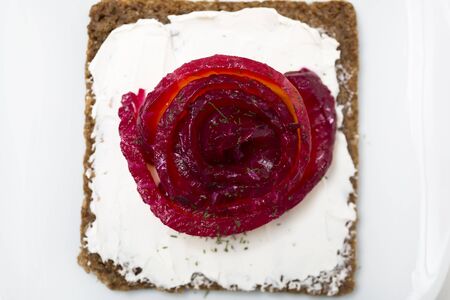 Appetizer of marinated salmon over a black bread with dill dyed with beetroot.の写真素材